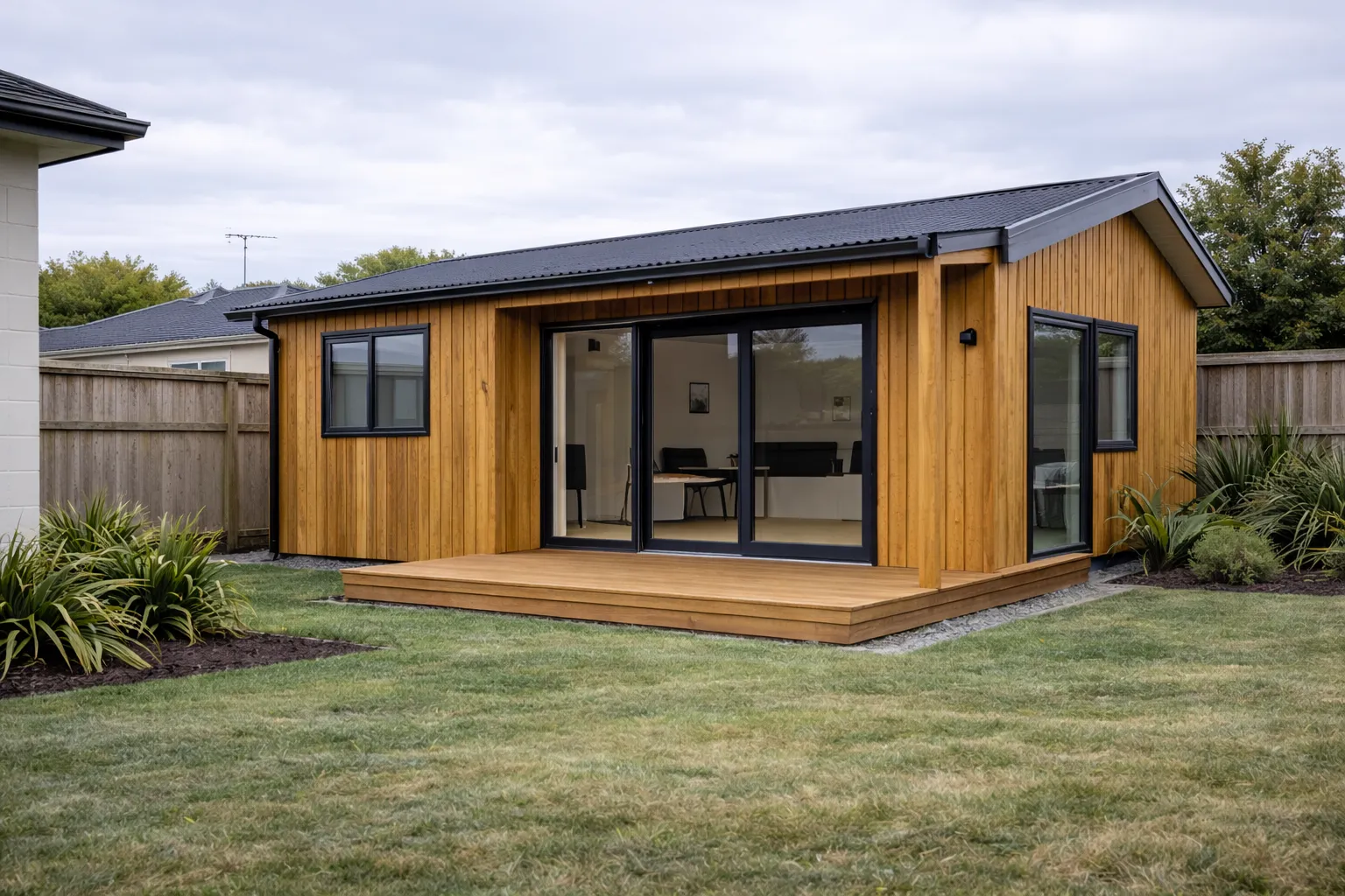 A modern 70m² cedar-clad dwelling with large glass doors and timber deck
